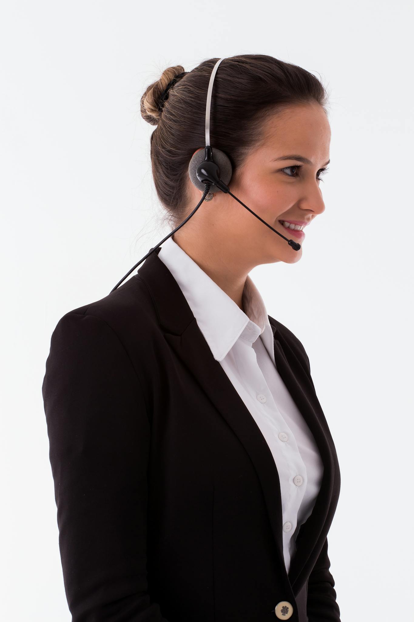 Cheerful call center agent wearing a headset and black blazer, ready to assist customers.